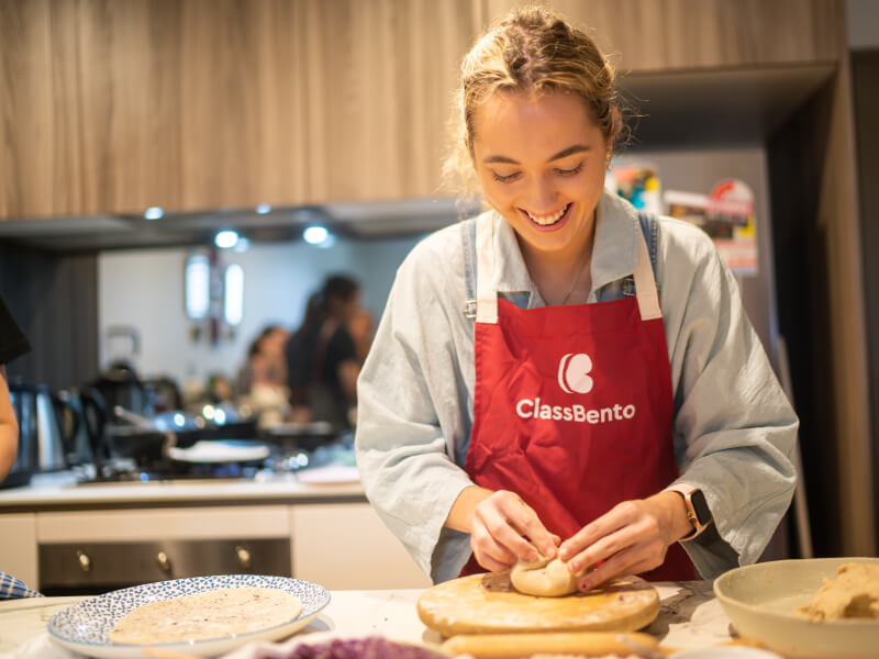 woman smiling and folding dough