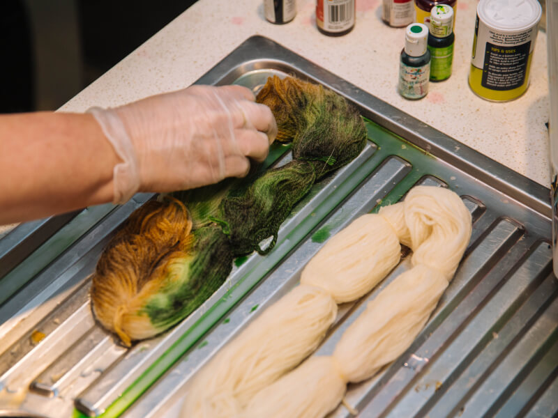 Person touching hand dyed yarn