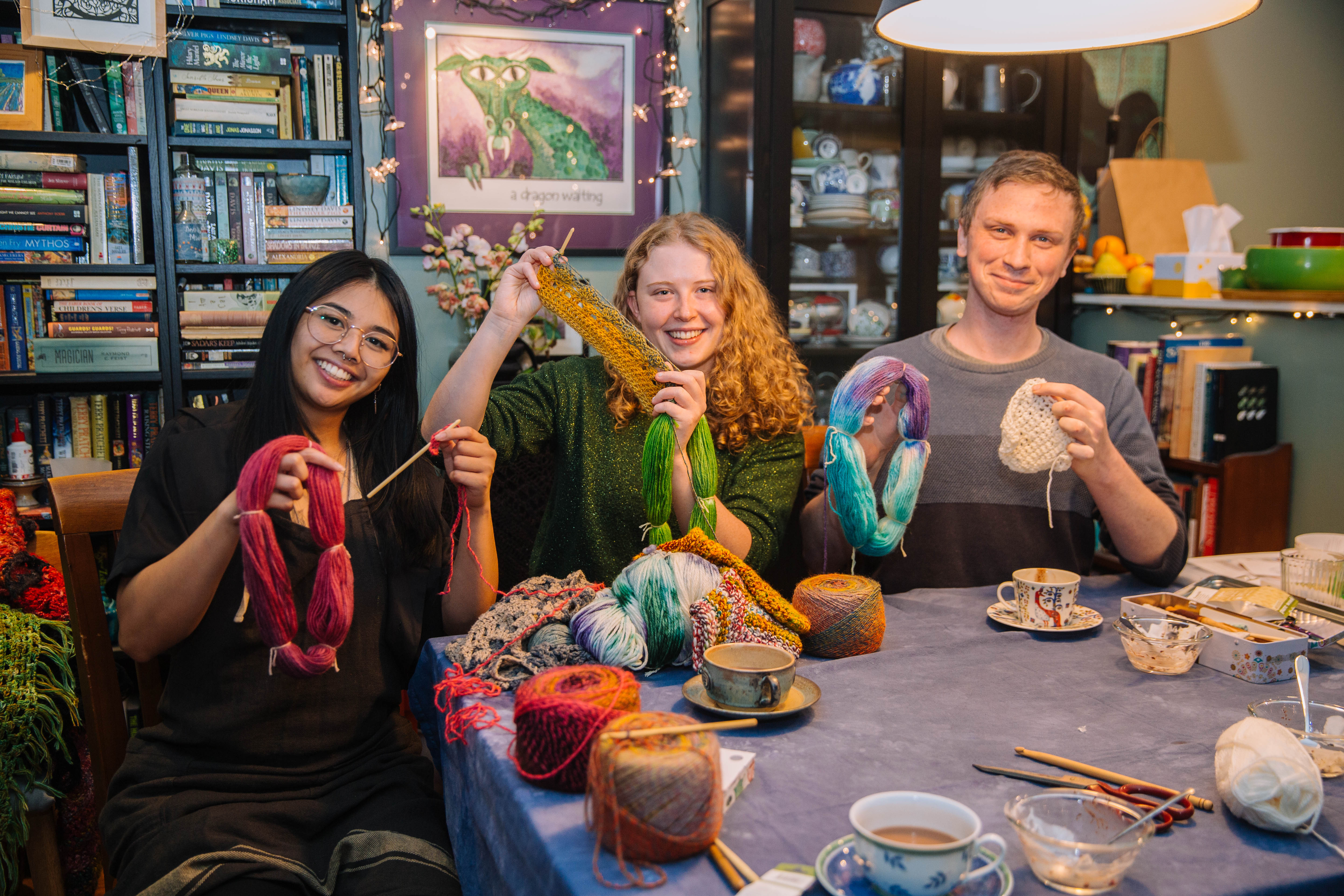 A group of people showing off their crochet work in progress