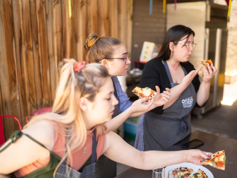 group of women tasting pizza at pizza making class for hens parties