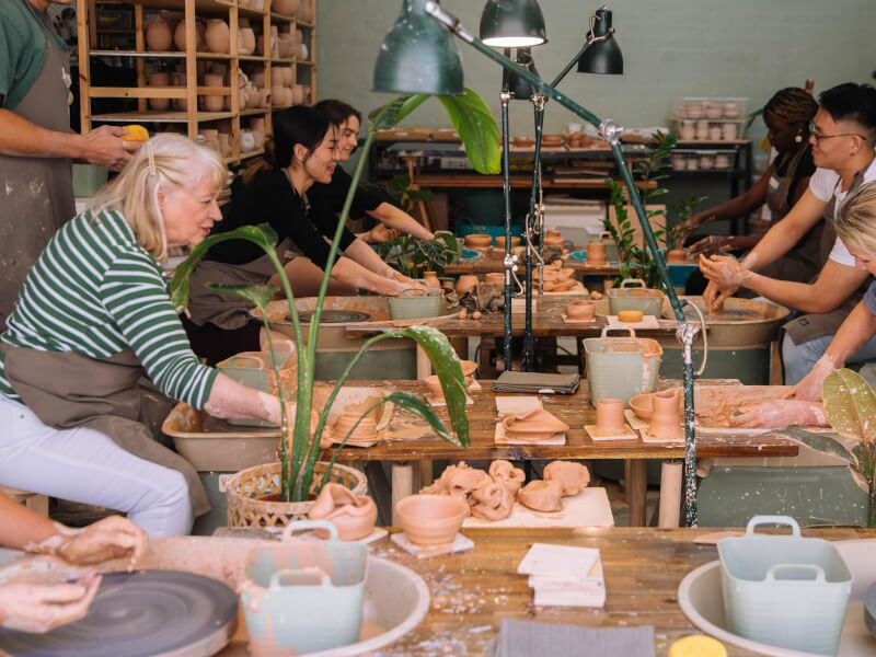 People wheel throwing in a studio