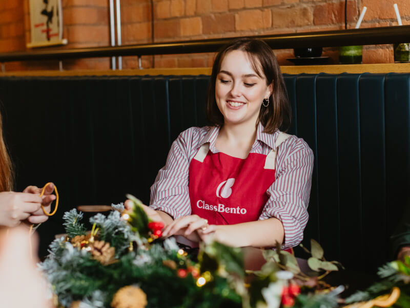 Smiling woman making a Christmas wreath