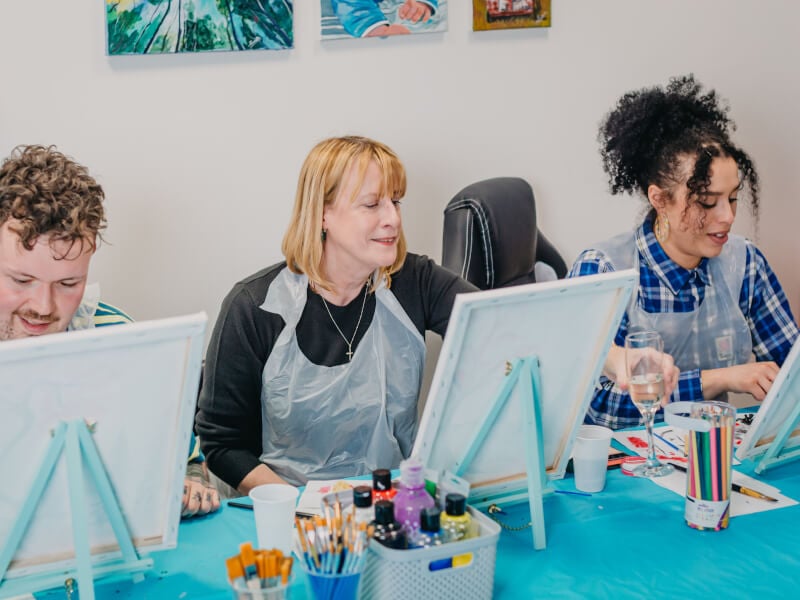 A mother and daughter enjoy a painting class together
