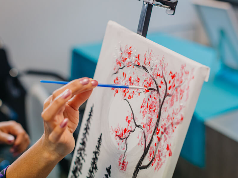 Close-up of woman painting cherry blossoms
