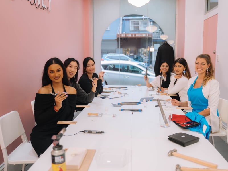 Women smiling at a jewellery making class