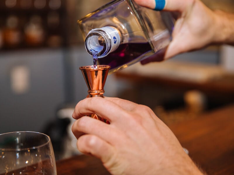 pouring cocktail with jigger