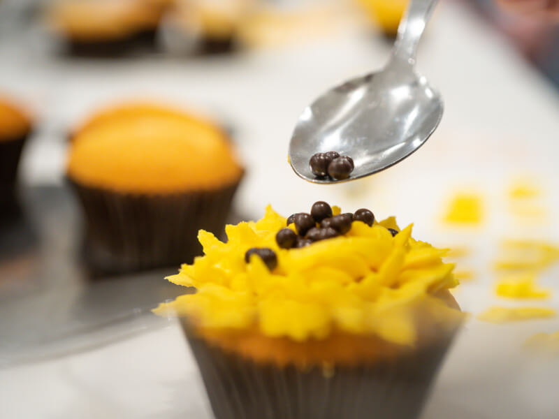adding toppings to cupcake