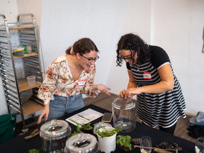 Two female colleagues building a terrarium at a terrarium class for team building