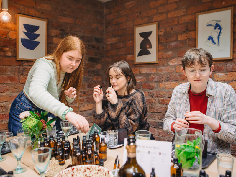 Three women at a perfume making workshop
