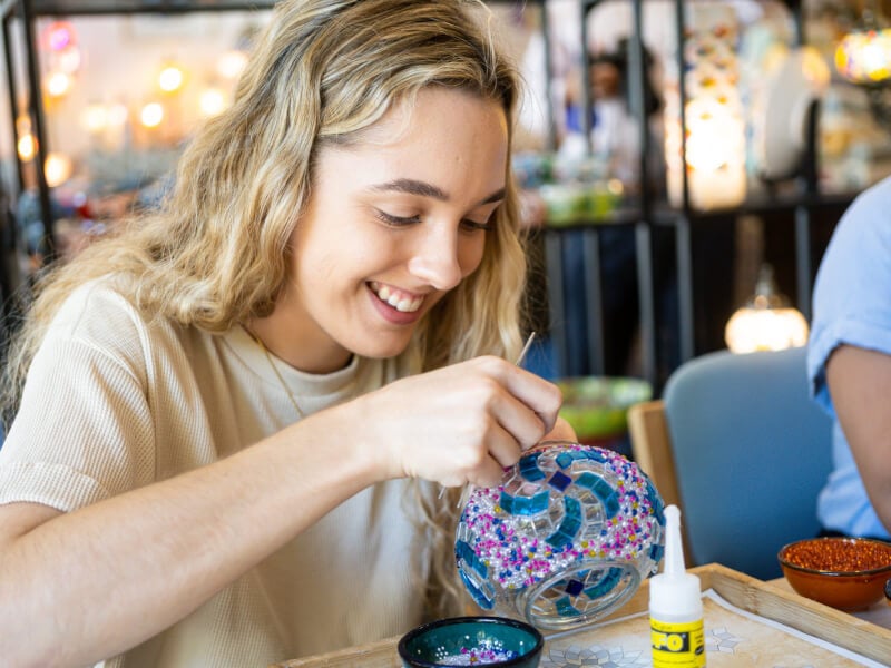 woman making a DIY Turkish mosaic lamp