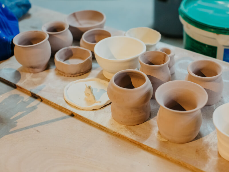 Unfired clay pots on a bench