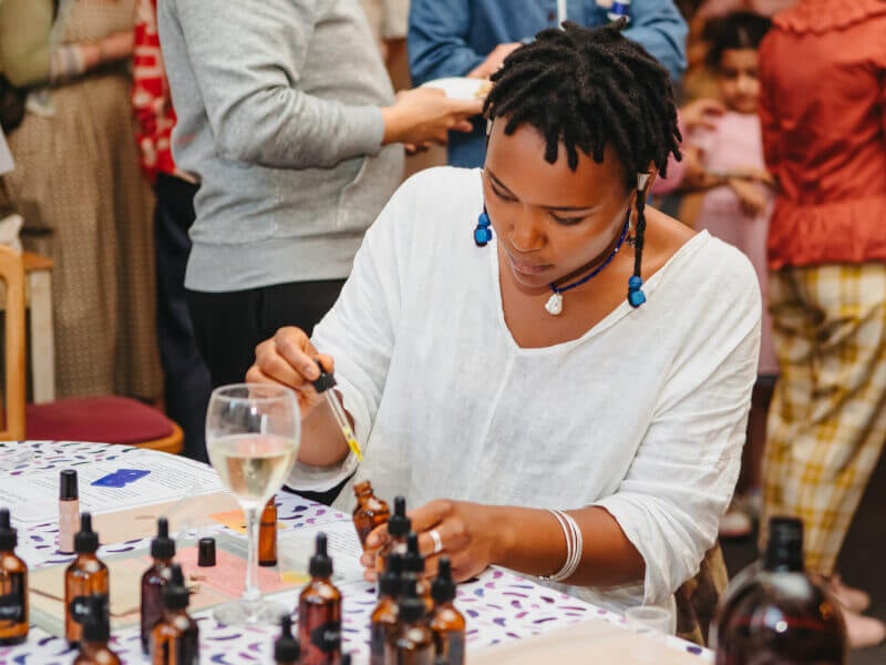 Woman drawing essential oil out of an amber bottle with a dropper