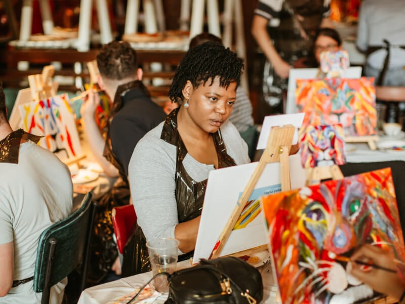 Woman looking intently at a canvas she is painting