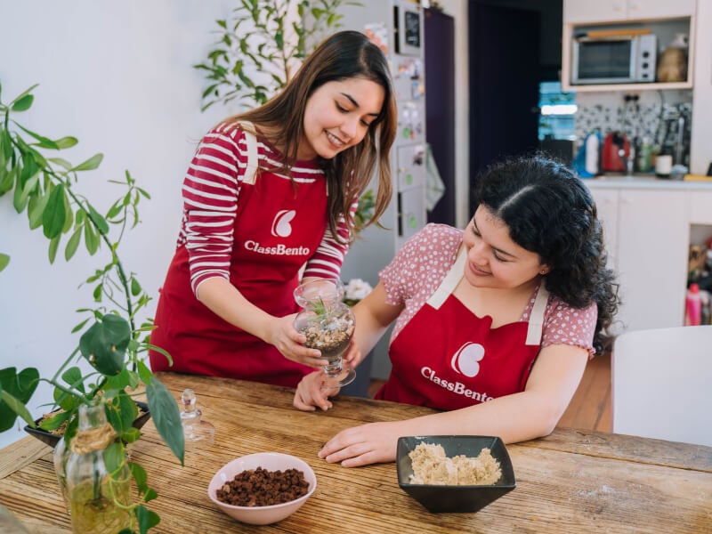 Woman showing another woman a small terrarium