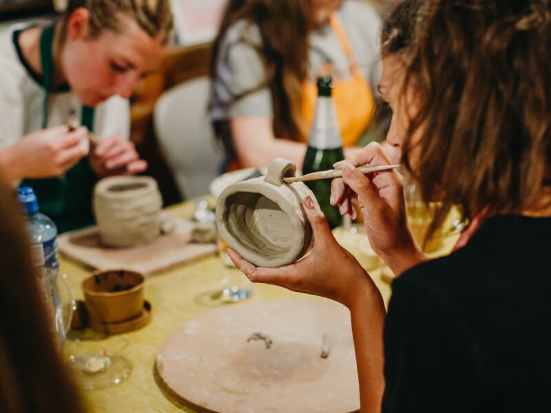 Woman working on a clay mug built by hand