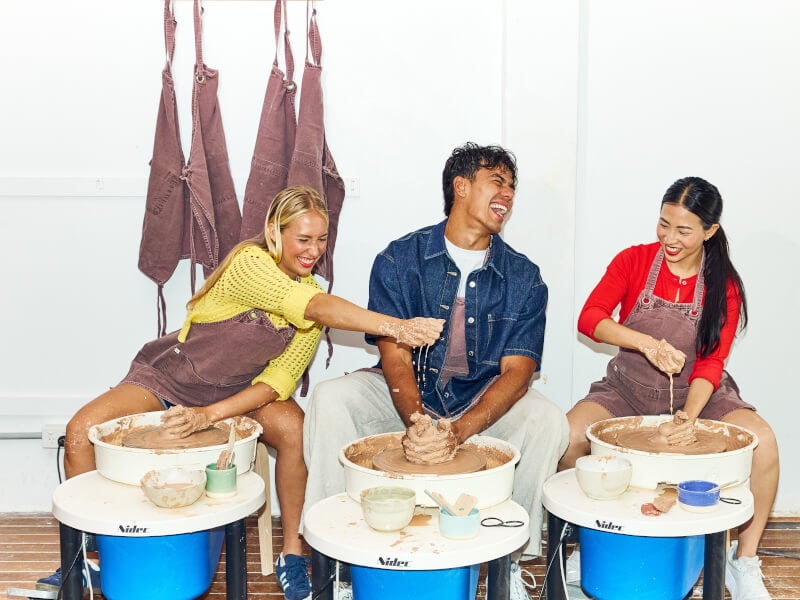 Group of people enjoying a wheel throwing class