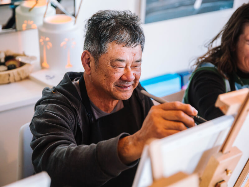 man smiling at paint and sip class