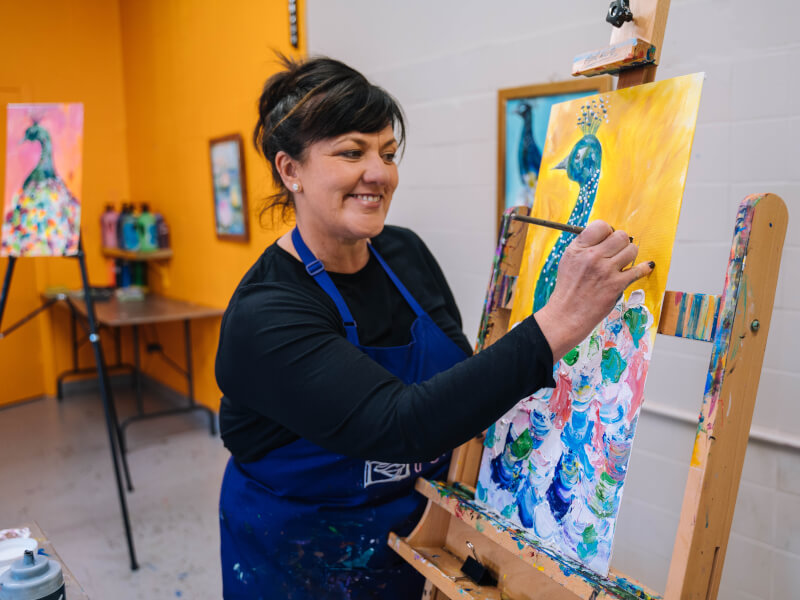 A woman looks happy while painting