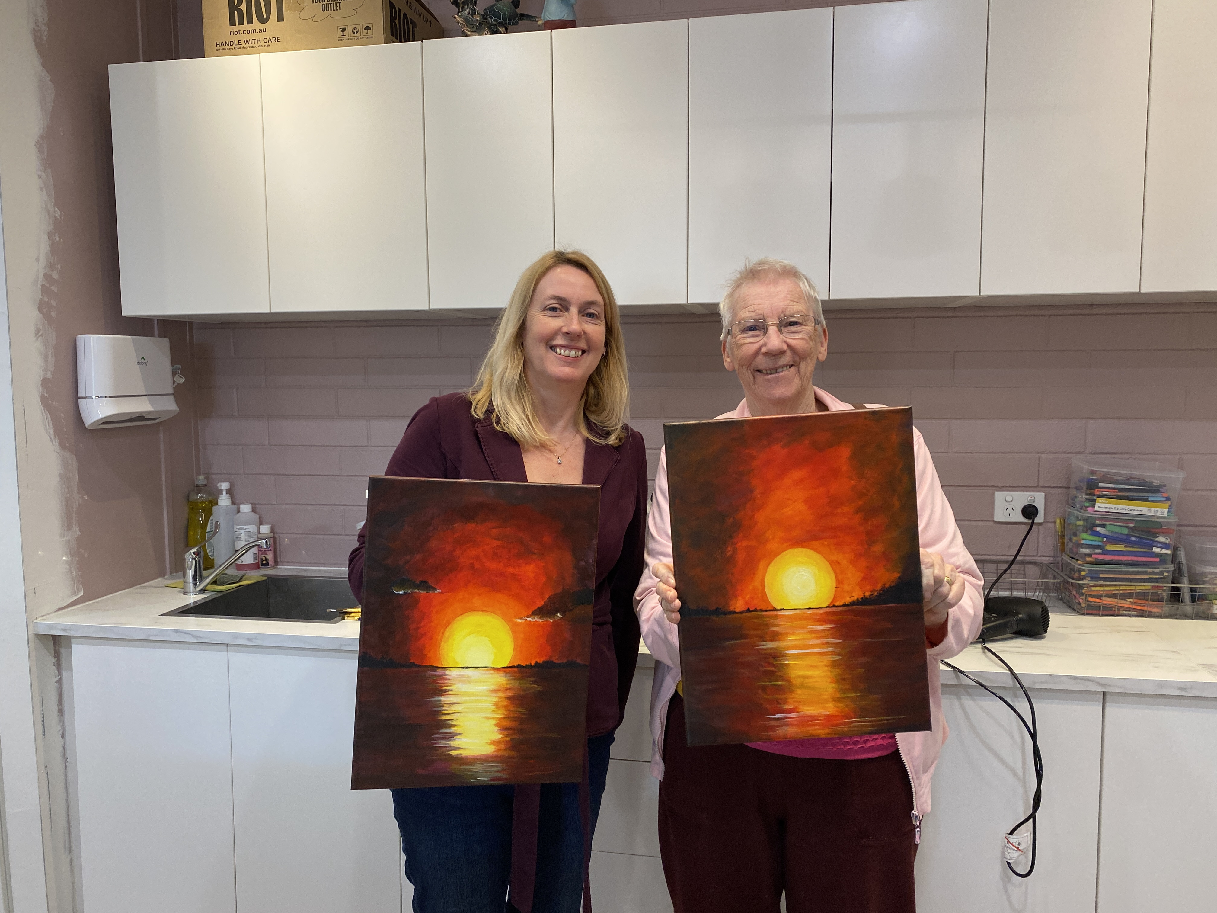 People holding their finished paintings