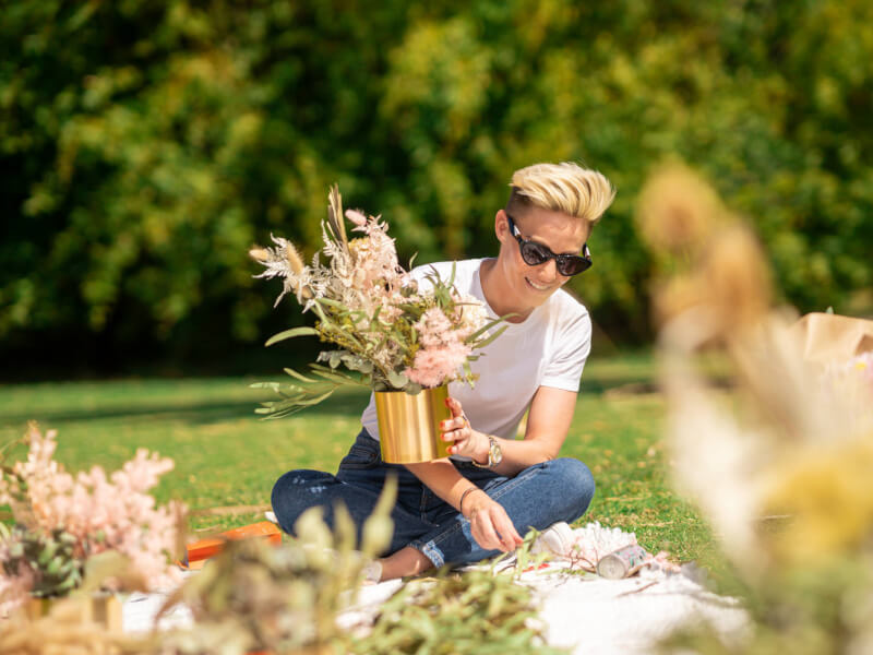 Woman enjoying an outdoor flower arranging class as her Mother's Day gift