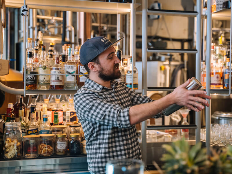 A bartender demonstrates cocktail shaking at a cocktail class
