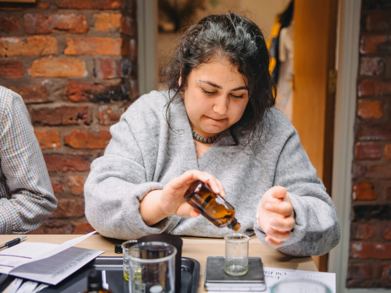 A woman focusing on blending scents at a Sydney candle making class