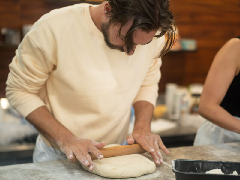 Man rolling out bread at baking class in Melbourne