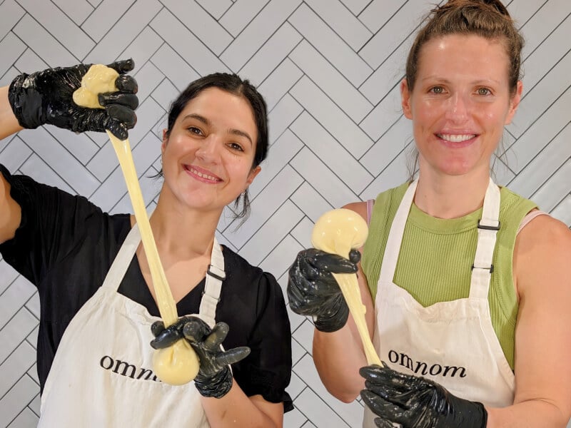 Two women making burrata