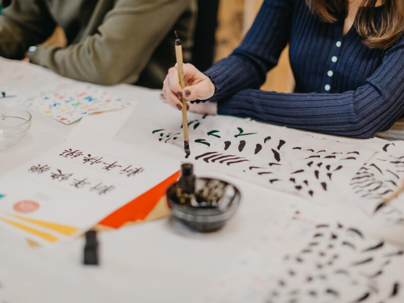 Couple practicing brush strokes at calligraphy class