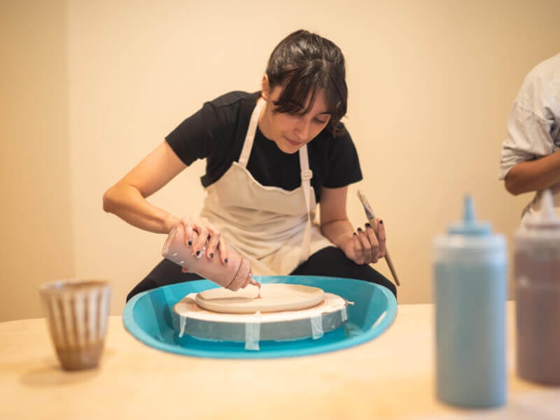 Woman painting ceramic plate