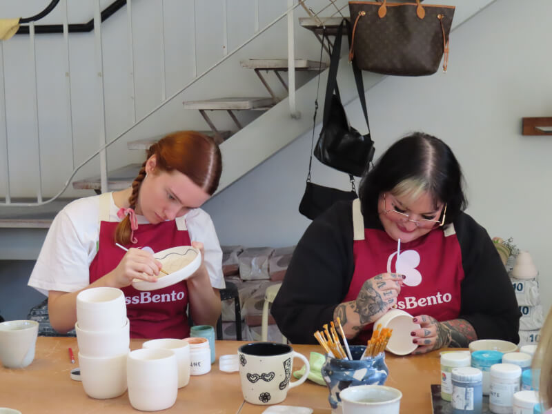 Two friends enjoy a ceramic painting class together