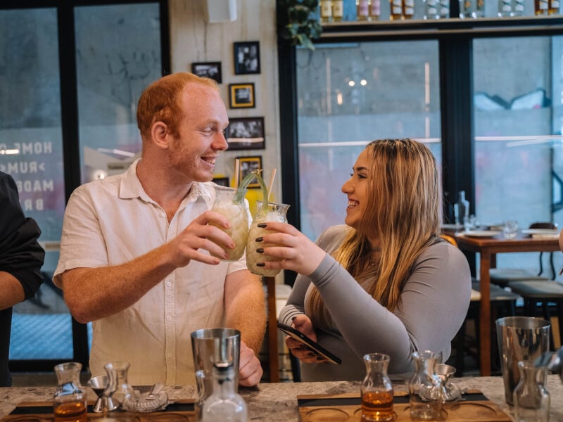 Two friends clink healthy fruit cocktails at a cocktail class