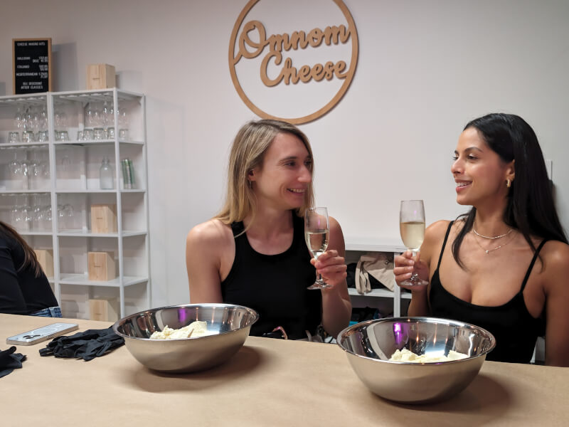 A couple drink champagne and make cheese at a romantic couples activity