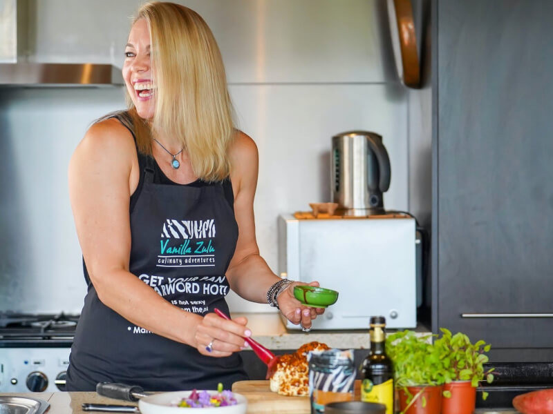 Smiling chef named Mel cooking in her industrial kitchen