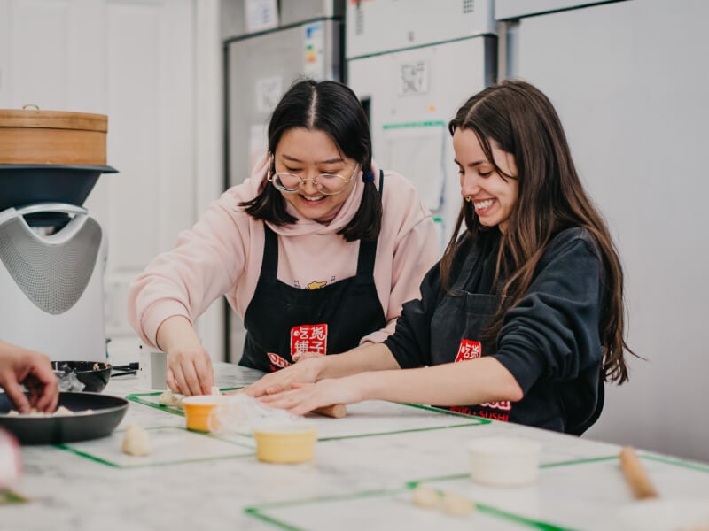 Two women making dumplings at a cooking class in Perth