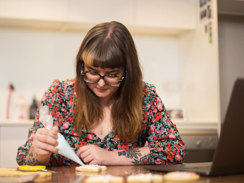 A woman decorates festive cookies