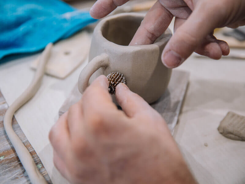 Hands moulding clay mug