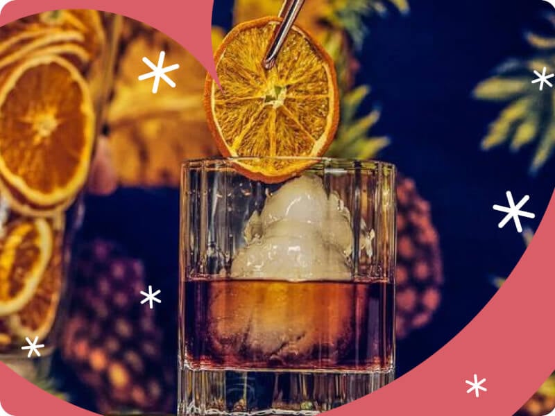adding preserved orange slice to cocktail