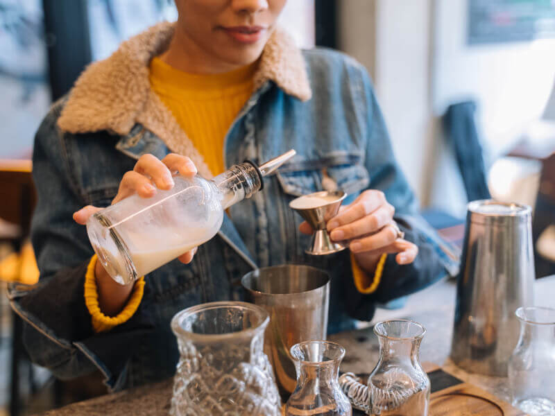 A woman making a pina colada at cocktail class she was gifted