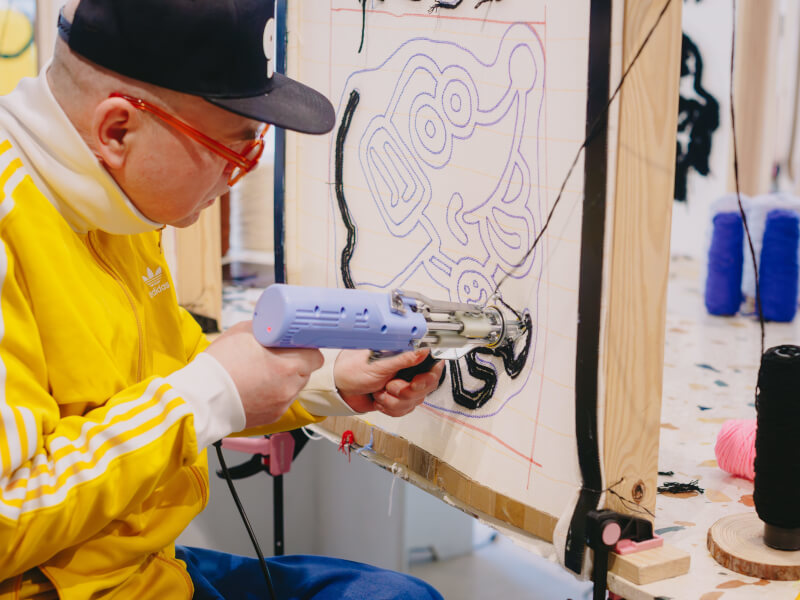 A man learning to tuft at a workshop