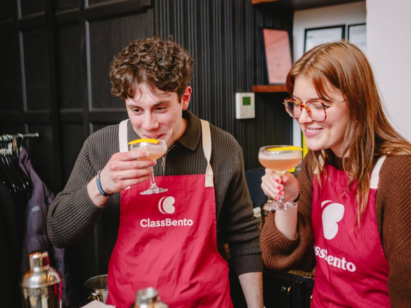A smiling man drinks a cocktail at workshop he was gifted
