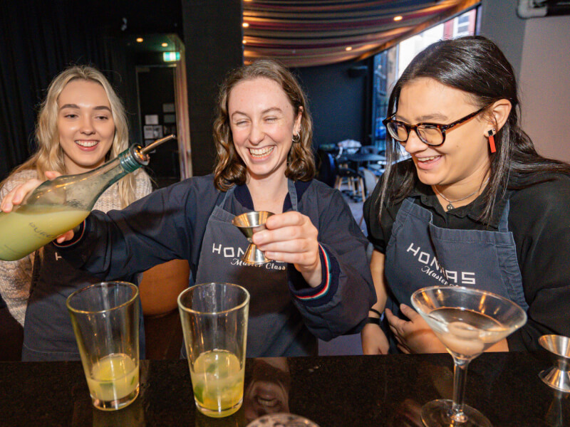 Three colleagues making cocktails