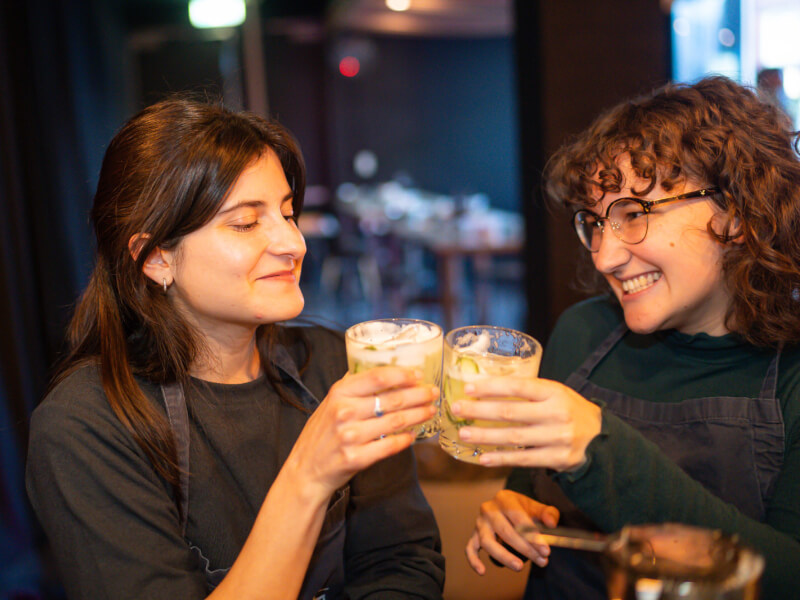 Two women celebrating Mother's Day with cocktails they made at a dumpling and cocktail class