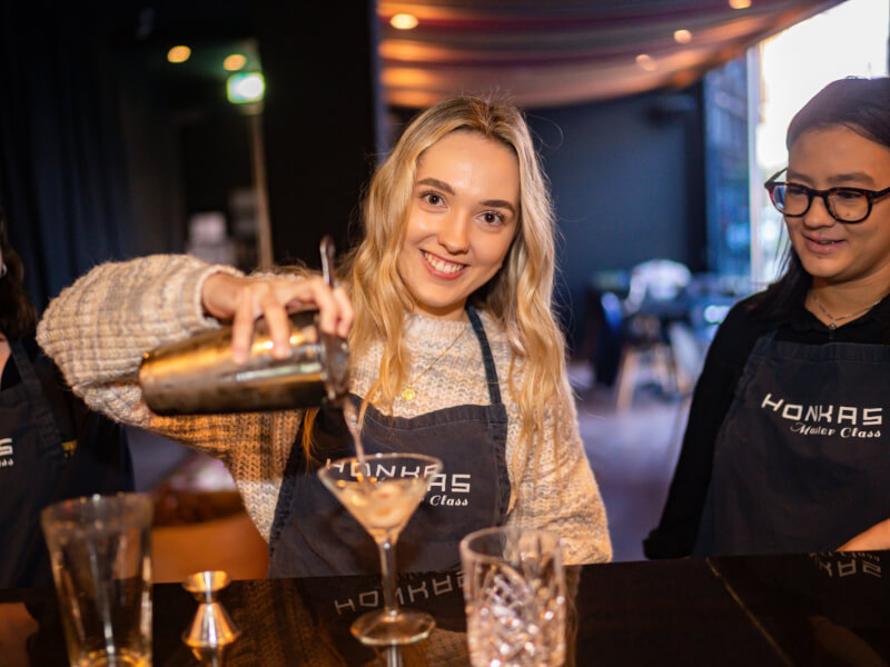 A group of colleagues make cocktails together