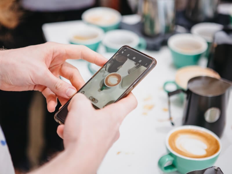 A person practices using their smarphone camera settings with food photography