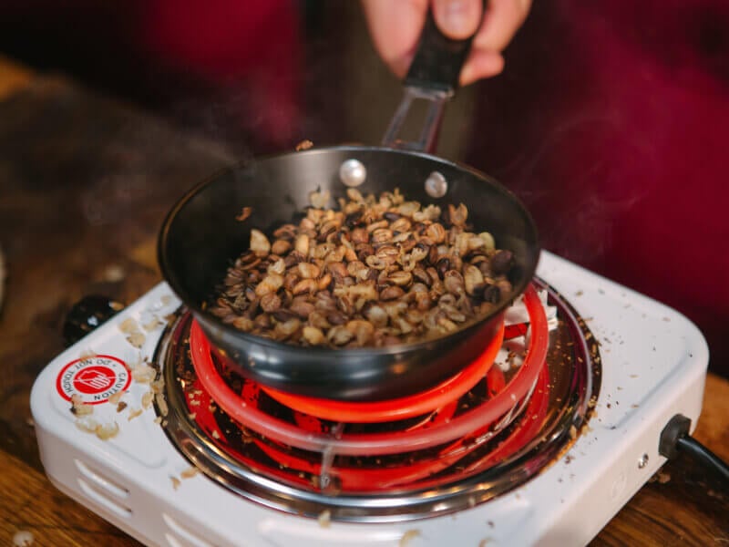 Coffee beans being roasted in a pan