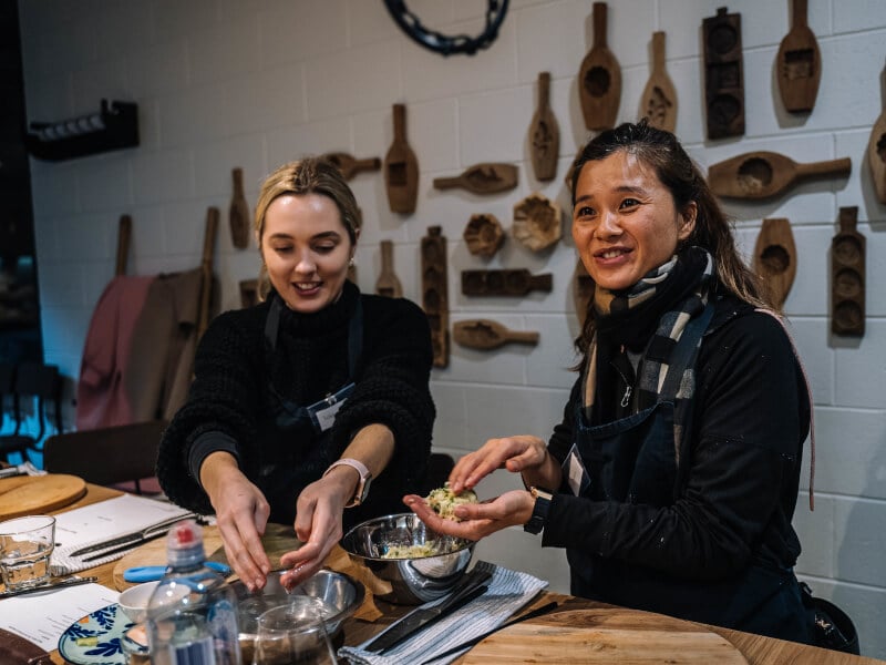 Two women cook together at an Asian cooking class