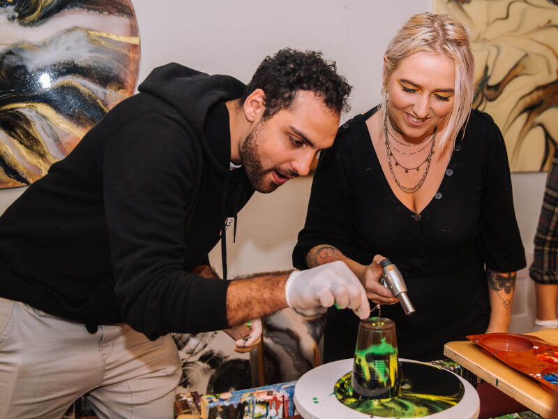 Couple pouring acrylic at art class experience gift