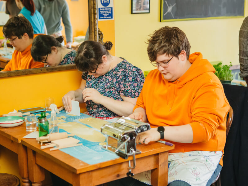 A couple make pasta at a couples cooking class