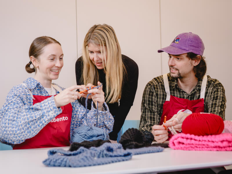 A couple learn to knit with teacher guidance at a workshop